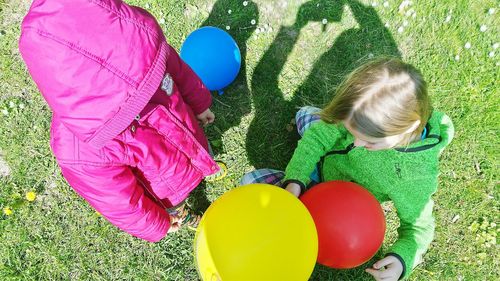 High angle view of girl sitting on balloons