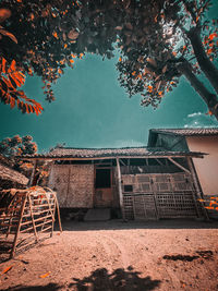 Building by trees against sky