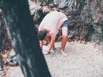 Rear view of woman walking on tree trunk