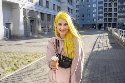 Portrait of smiling young woman standing in city