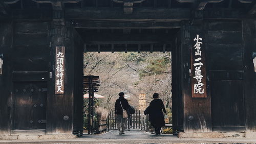 Rear view of people walking outside building