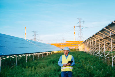 Engineer looking away standing at solar plant