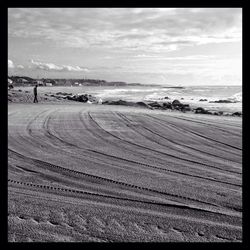 Scenic view of beach against cloudy sky