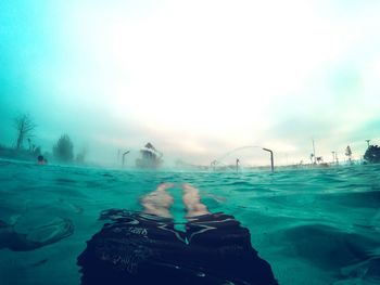 Low section of man swimming in sea