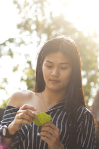 Close-up of young woman holding leaves