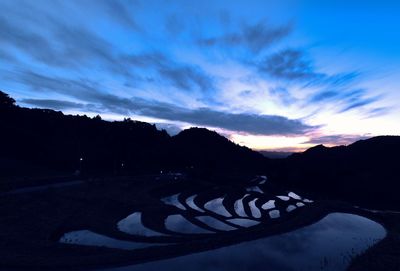 Scenic view of silhouette mountains against sky at sunset