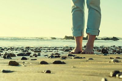 Low section of woman standing on beach