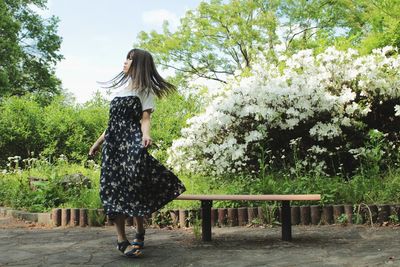 Woman tossing hair while standing in park