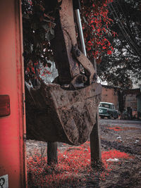 Rusty metallic structure against trees and abandoned building