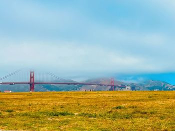 View of suspension bridge against cloudy sky  golden gate bridge 