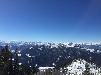 Scenic view of snowcapped mountains against clear blue sky