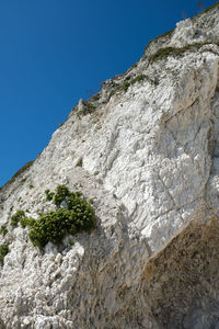 Low angle view of rock formation against clear blue sky