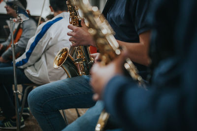 Midsection of saxophonist playing saxophone