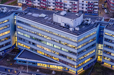 Aerial view of an office building at dusk with the interior lighting on