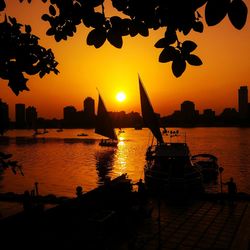 Silhouette of boats in river during sunset