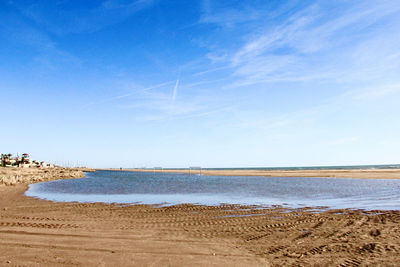 Scenic view of beach against blue sky