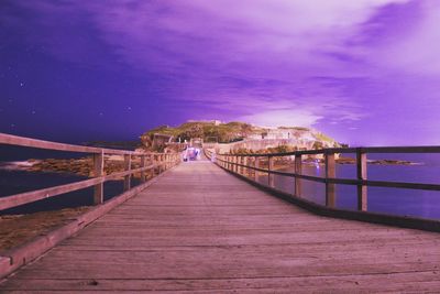 View of bridge over calm sea against blue sky