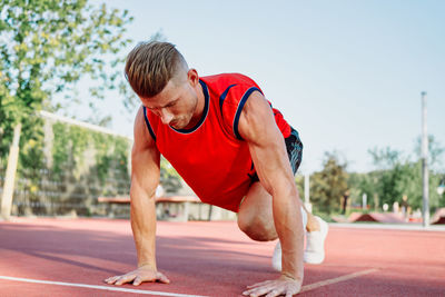 Side view of young man exercising in gym