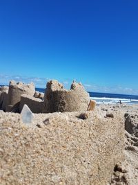 Scenic view of beach against clear blue sky