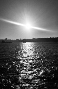 Scenic view of sea against bright sun