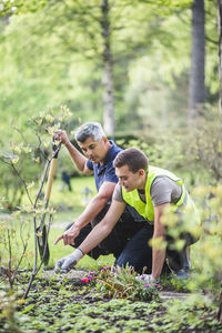 Instructor pointing at plants to trainee at garden