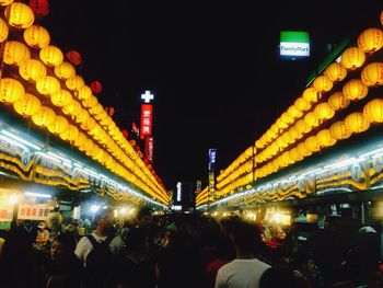 People walking in illuminated city at night