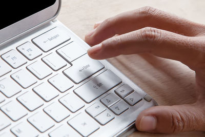 Close-up of hand using computer keyboard on table