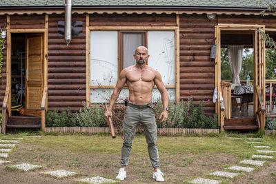 Full length of shirtless man standing outdoors