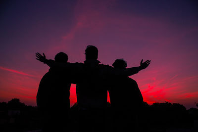 Silhouette man standing against orange sky