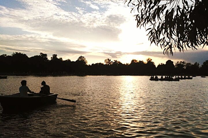 sunset, lake, silhouette, nature, two people, travel destinations, outdoors, outdoor pursuit, water, vacations, scenics, beauty in nature, sunbeam, tranquility, leisure activity, togetherness, people, landscape, pedal boat, beauty, tree, sky, nautical vessel, sun, human body part, adult, rowing, day