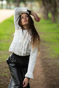 Portrait of young woman standing on field