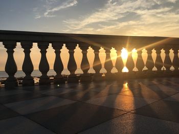 Sunlight falling on railing against sky during sunset
