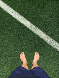 Low section of man standing on soccer field