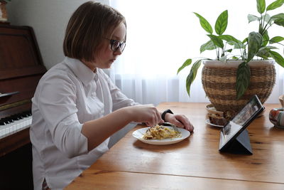 Woman sitting on table at home