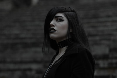 Portrait of young woman looking away outdoors