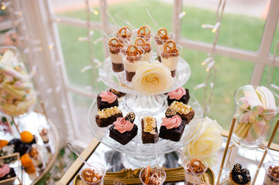 From above sweet delicious creamy chocolate cakes decorated with flowers on glass stand in cafe