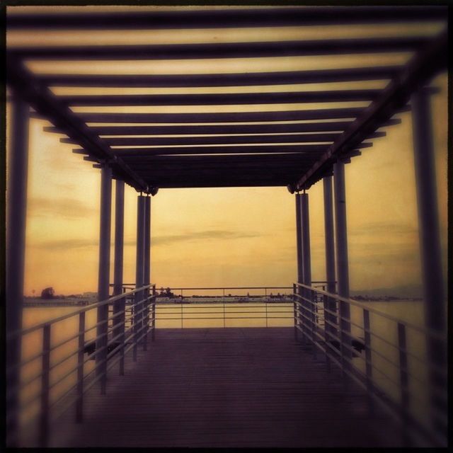 sunset, sea, built structure, railing, sky, pier, architecture, water, wood - material, tranquil scene, tranquility, horizon over water, scenics, nature, auto post production filter, cloud - sky, transfer print, bridge, silhouette, no people