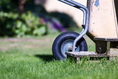 Wheelbarrow on grassy field at garden