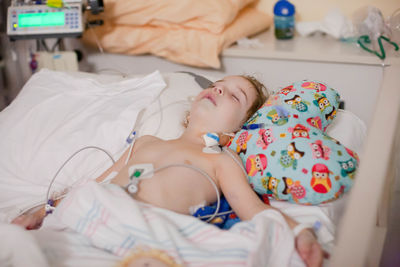 Boy sleeping on bed at home