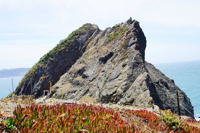 Scenic view of rock by sea against sky