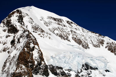 Scenic view of snowcapped mountains against clear blue sky