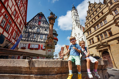Low angle view of woman standing against building