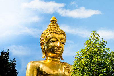 Close up of head larg golden buddha on blue sky background ,thailand