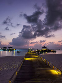 Pier over sea against sky during sunset