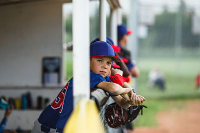 Boy in dugout during little league baseball game