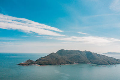 Scenic view of sea and mountains against blue sky