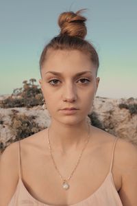 Portrait of young woman against sky