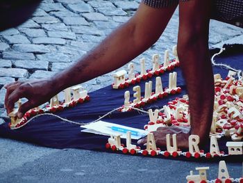 High angle view of vendor arranging toy train on fabric at street market