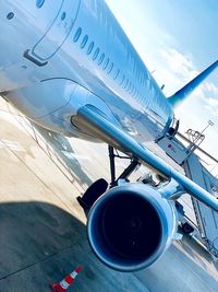 Low angle view of airplane at airport runway against sky