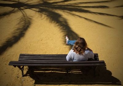 High angle shot of woman sitting on bench outdoors